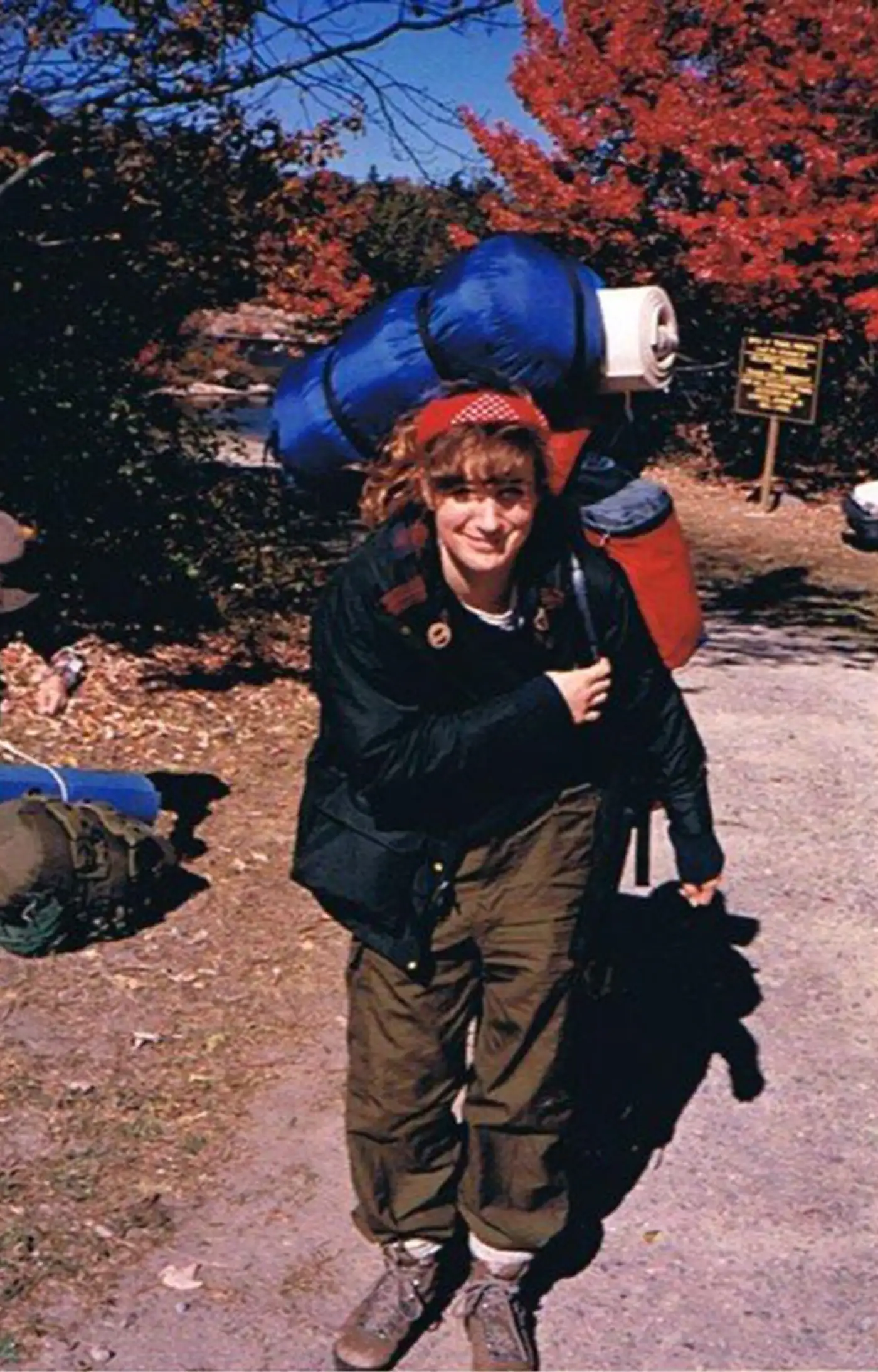 The author at the trailhead in Killarney Provincial Park in grade 10. She has a large backpack on, kaki hiking pants, and a red bandana on her head.